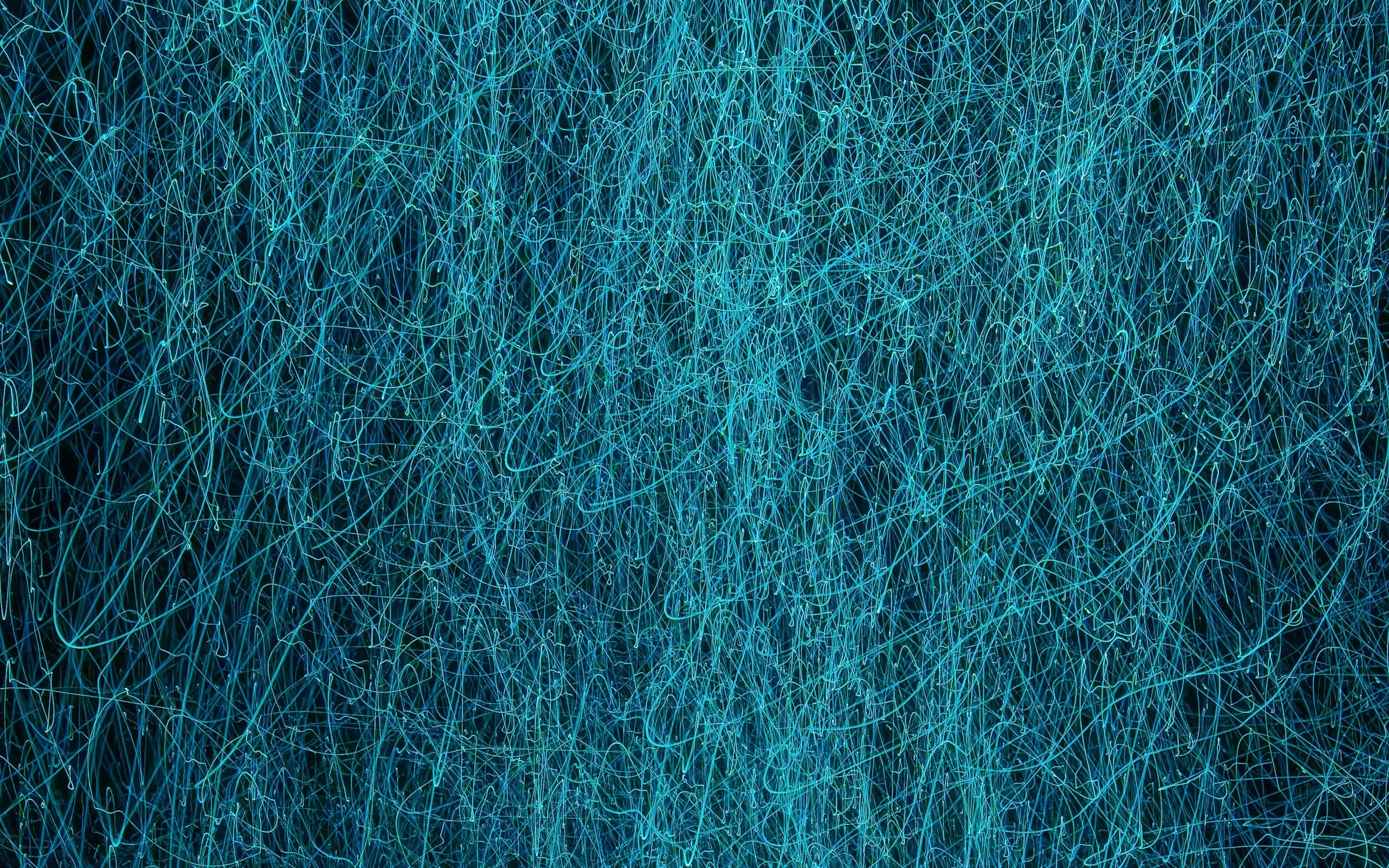 Abstract tangle of fine blue light lines stretching across a dark background.